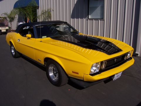 2002 Ford Mustang - This yellow 1971 Ford Mustang convertible displays black racing stripes and chrome wheels.