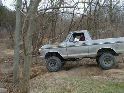 1979 Ford Bronco - A silver 1978 Ford Bronco navigates a wooded trail.