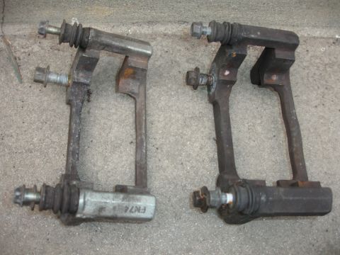 1993 Ford Taurus - Two used brake caliper brackets are shown, with visible rust and one bearing a part number.