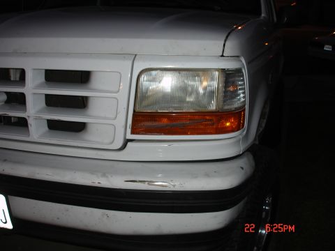 1996 Ford Bronco - Front view of a white Ford truck, showing the grille and headlight assembly with a scratched bumper.