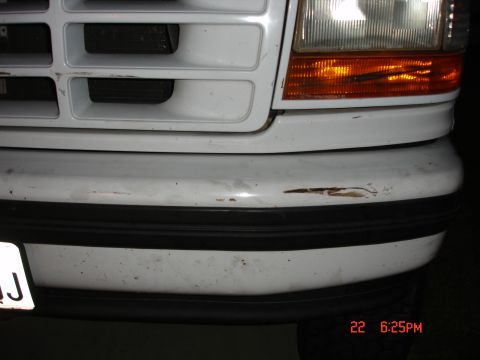 1996 Ford Bronco - Close-up of a white Ford truck's front bumper and grille, revealing signs of wear and tear.