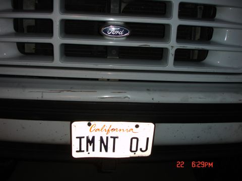 1996 Ford Bronco - Close-up of a Ford emblem on a truck's grille above a California license plate.