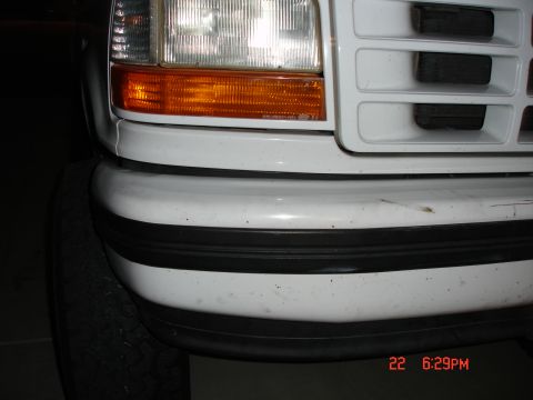 1996 Ford Bronco - Front view of a white Ford truck, likely from the early to mid-1990s, with visible bumper damage.