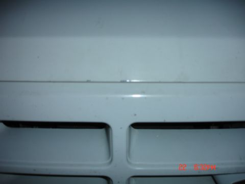 1996 Ford Bronco - Close-up of a white vehicle's front grille, showing horizontal openings and a watermark.