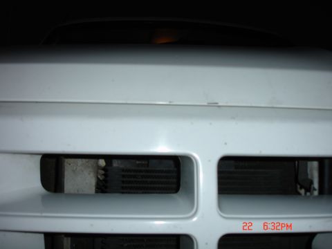 1996 Ford Bronco - Close-up of a white vehicle's front grille, revealing the radiator behind the horizontal slats.