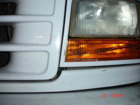 1996 Ford Bronco - Close-up of a white Ford Bronco's front grille and headlight assembly, showing the distinctive horizontal bar design.