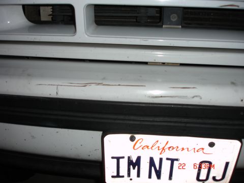 1996 Ford Bronco - Close-up of a white front bumper with visible scratches and a California license plate.