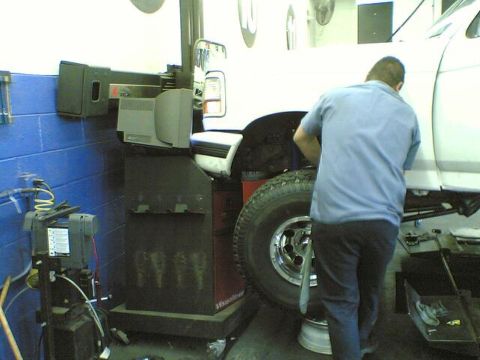 1996 Ford Bronco - White 1996 Ford Bronco undergoing service on a lift in a garage.