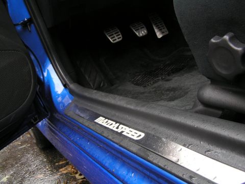 2003 Mazda Protege - The interior door sill of a blue vehicle displays the "MAZDASPEED" branding, with pedals visible in the footwell.
