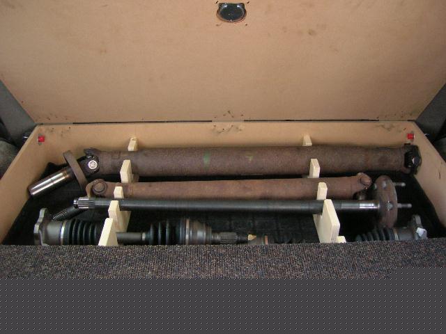 Driveshafts and CV axle shafts stored in a foam-lined wood crate