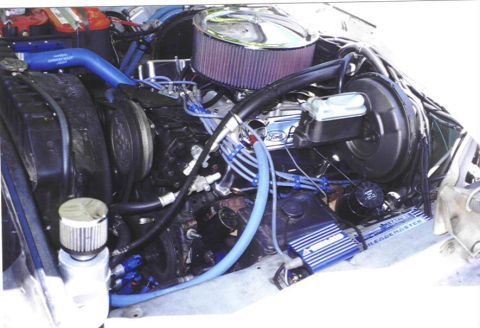 1979 Ford Bronco - The engine bay of a 1979 Ford Bronco shows a Ford engine with custom blue hoses and a chrome air cleaner.