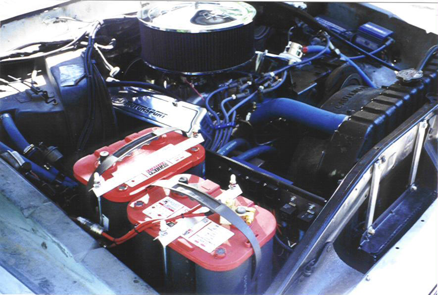 Engine bay with dual red top batteries and blue hoses