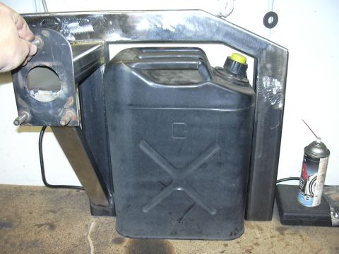 1991 Ford Bronco - A shop-fabricated bare-steel swing-out carrier holds a black Blitz steel jerry can with a yellow vent cap, the weld beads still unpainted.…