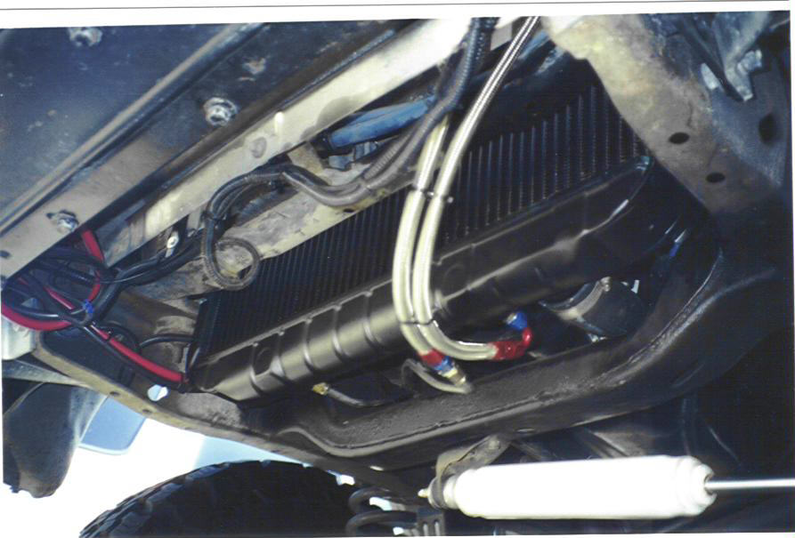 Underbody view of vehicle chassis showing transmission cooler lines and radiator