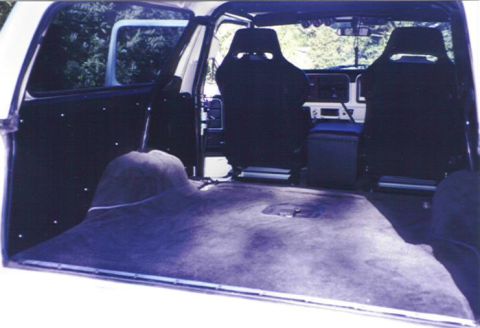 1979 Ford Bronco - The interior of a 1979 Ford Bronco features racing seats and a spacious, carpeted cargo area.
