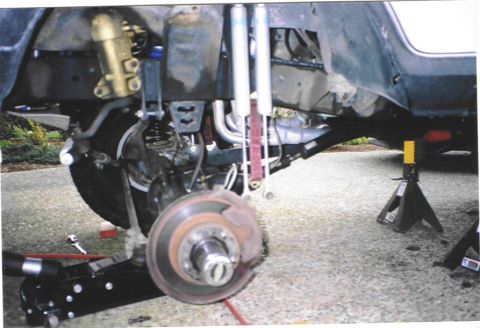 1979 Ford Bronco - Vehicle suspension and undercarriage components are visible while the vehicle is supported by jack stands.
