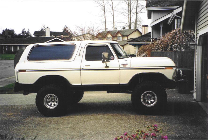 White 1979 Ford Bronco lifted with large tires parked in a driveway