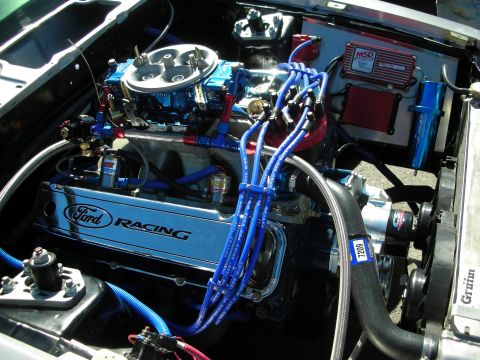 1998 Ford Crown Victoria - engine bay featuring a Ford Racing valve cover, blue spark plug wires, twin throttle bodies and a red MSD ignition box.