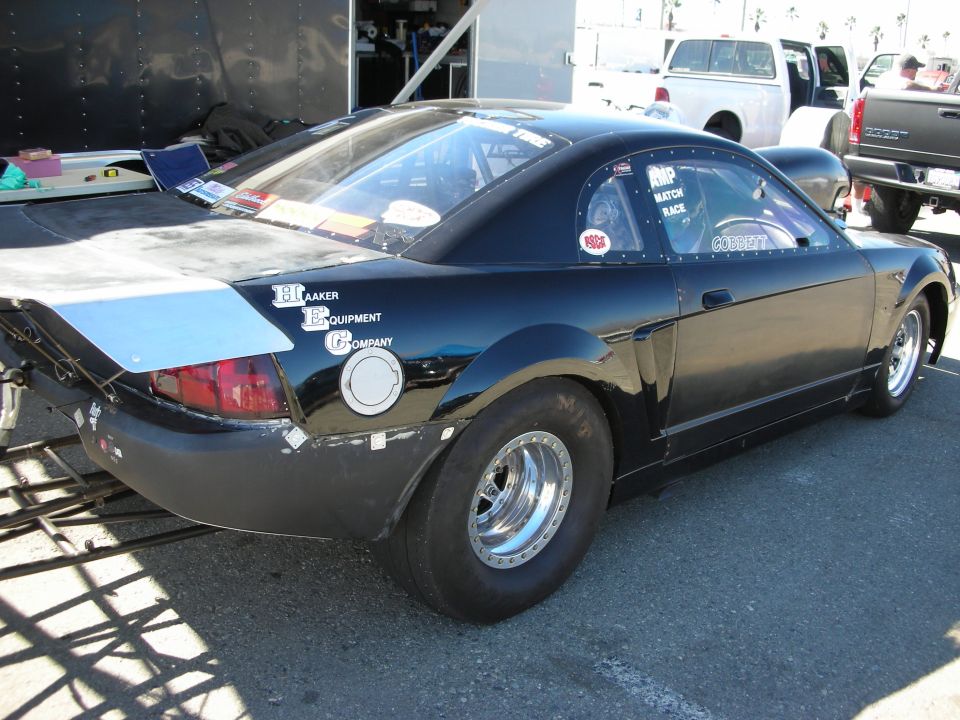 Black New Edge Mustang drag car with skinny front tire in pit
