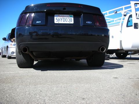 1998 Ford Crown Victoria - low rear view of a black Ford SVT Cobra showing the dual exhaust tips and California plate 5HYD038.