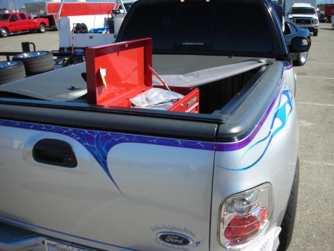 1998 Ford Crown Victoria - bed of a silver flamed Ford pickup holding an open red toolbox, parked in a show or pit lot.