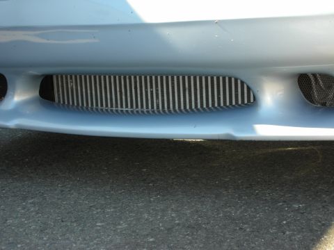 1998 Ford Crown Victoria - light blue lower front bumper with a mesh-covered opening exposing an intercooler or radiator core.