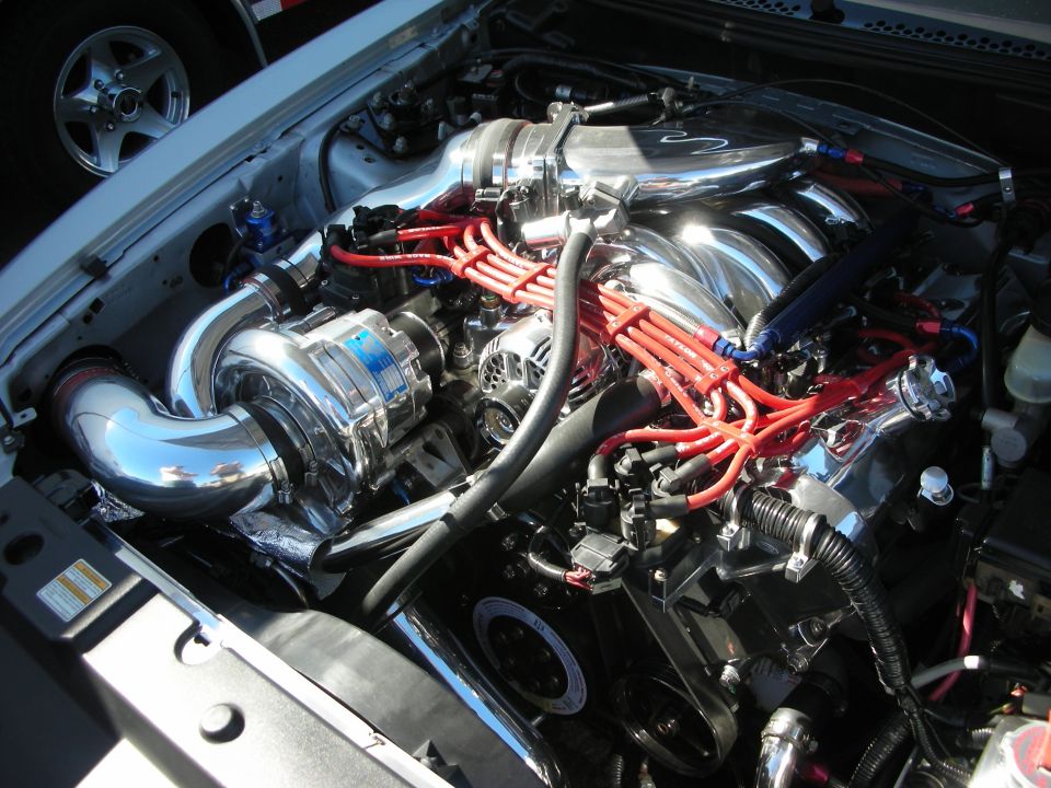 Engine bay with polished centrifugal supercharger and red plug wires