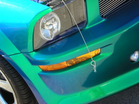1998 Ford Crown Victoria - Detail of the front headlight and amber turn signal on a color-shifting blue-green custom Mustang.