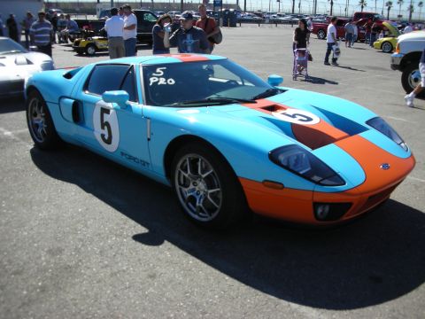 1998 Ford Crown Victoria - Light-blue and orange Gulf-livery Ford GT marked with number 5, parked at an outdoor car show.