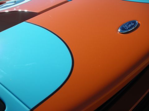 1998 Ford Crown Victoria - Blue Ford oval emblem on the orange front clip of a Ford GT with a contrasting light-blue stripe.