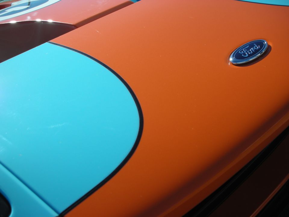 Ford oval badge on the orange and blue hood of a Ford GT