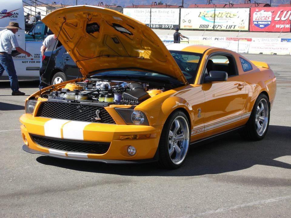 Orange Shelby GT500 Mustang with white stripes and hood open