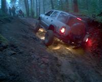 2002 GMC Yukon - 2002 GMC Yukon navigating a challenging off-road course in a wooded area.