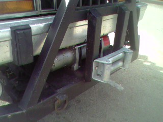1994 Ford Bronco - Vehicle rear bumper with a winch and custom metal guard attached.