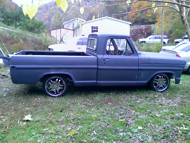 Dark gray pickup truck, side view, custom wheels, lowered stance