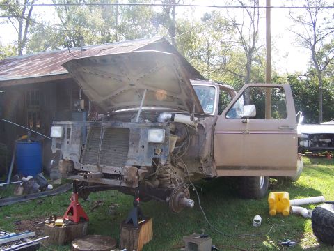 1981 Ford Bronco - Ford Bronco undergoing front-end repair with hood and door open.
