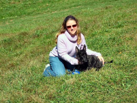 1985 Ford LTD Crown Victoria - A woman and her dog enjoy a sunny day outdoors in a grassy field.