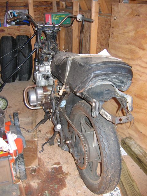 1985 Ford LTD Crown Victoria - This motorcycle appears to be in a state of disrepair or disassembly within a wooden shed.
