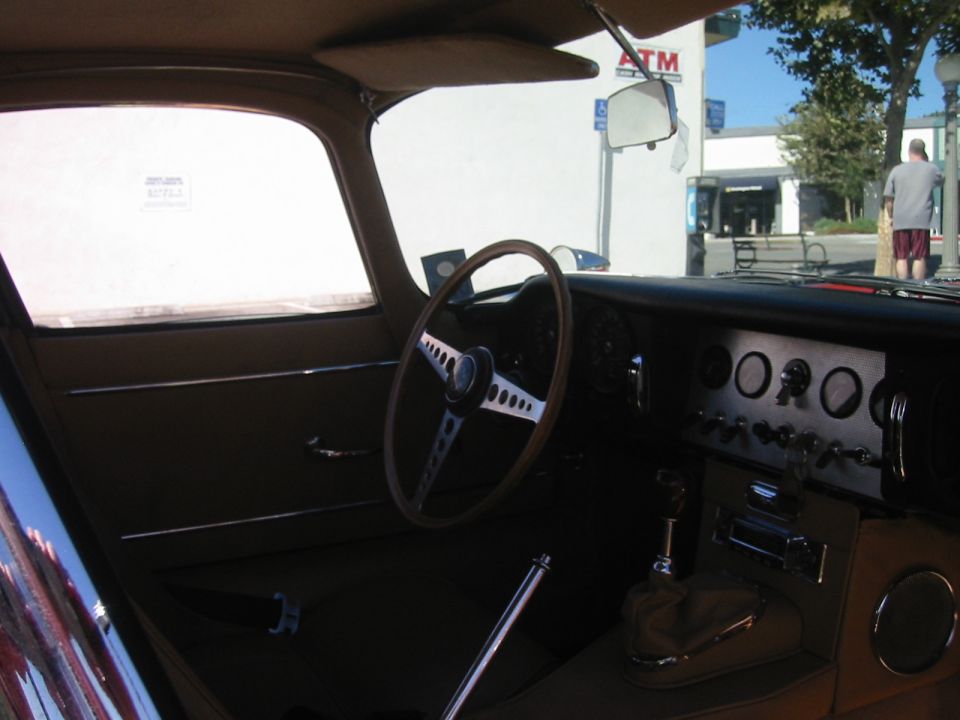 Classic Jaguar interior with wood steering wheel, chrome shifter, and gauge cluster