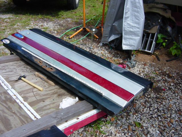 Tailgate with red and silver stripes, showing rust spots