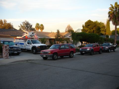 1992 Ford Explorer - Several vehicles, including a red 1992 Ford Explorer, are parked along a residential street.