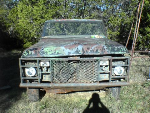 1991 Ford Bronco - This weathered truck, possibly a Ford F-Series or Bronco, shows significant rust and a custom front bumper/grille guard.