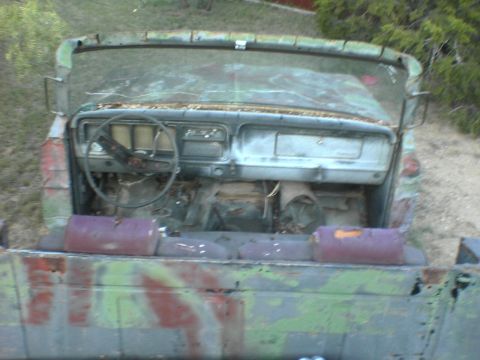 1991 Ford Bronco - The interior of a weathered truck shows a steering wheel and dashboard with most of the interior removed.