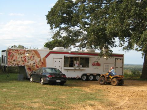 1986 Ford Bronco - A Papa John's pizza trailer is parked in a grassy area with a sedan and an ATV nearby.