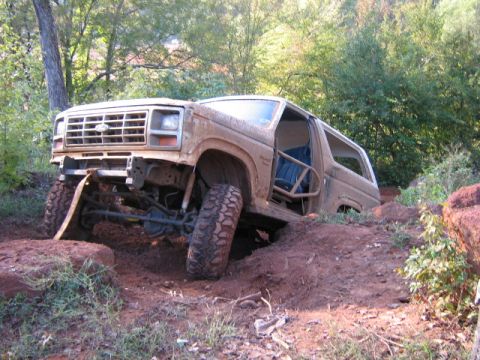 1986 Ford Bronco - This 1986 Ford Bronco is shown off-roading through a dirt trail with significant inclines.
