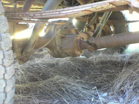 1991 Ford Bronco - Undercarriage view of a truck's rear axle and driveshaft, showing rust and wear.