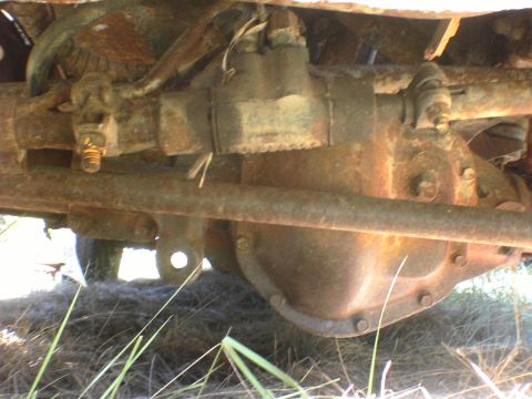 1991 Ford Bronco - Close-up view of heavily rusted undercarriage components, including the differential and steering mechanism.