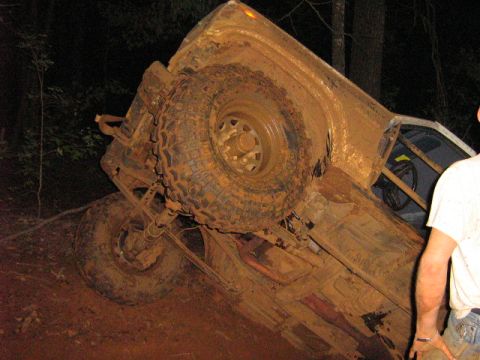 1986 Ford Bronco - This 1986 Ford Bronco is heavily covered in mud and overturned on its side in a wooded area.