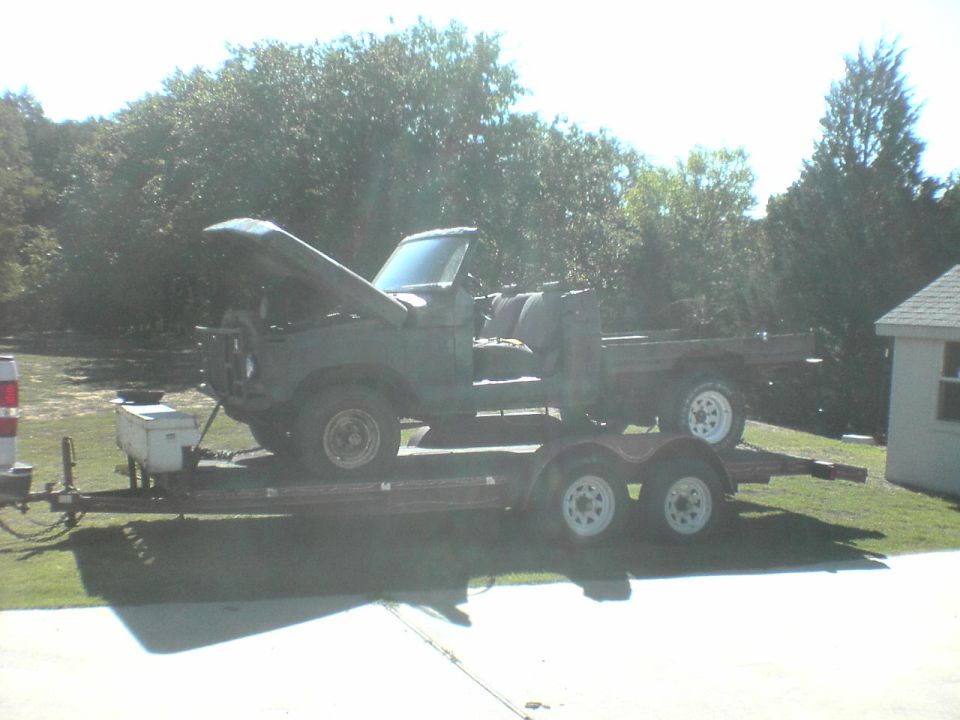 1991 Ford Bronco on a dual-axle trailer with hood open