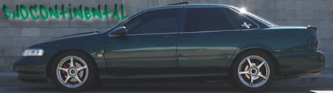 1993 Ford Taurus - Side view of a dark green sedan with tinted windows and a spoiler.